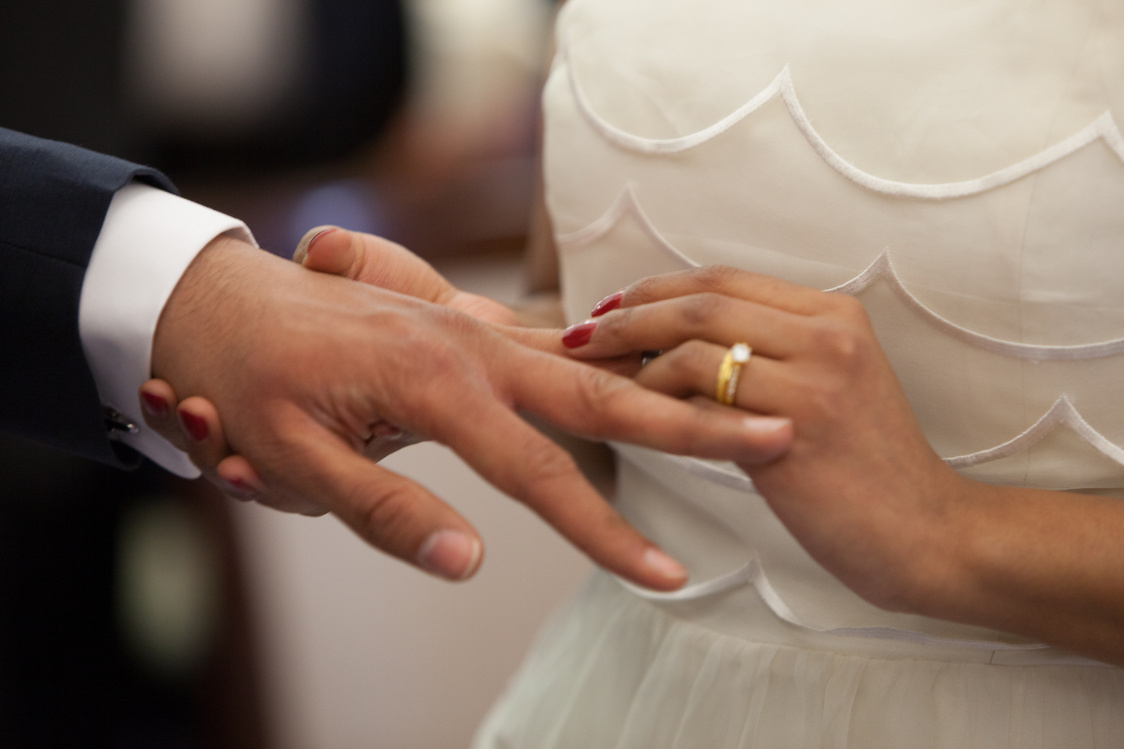 Bride Putting a Ring on Grooms Hand